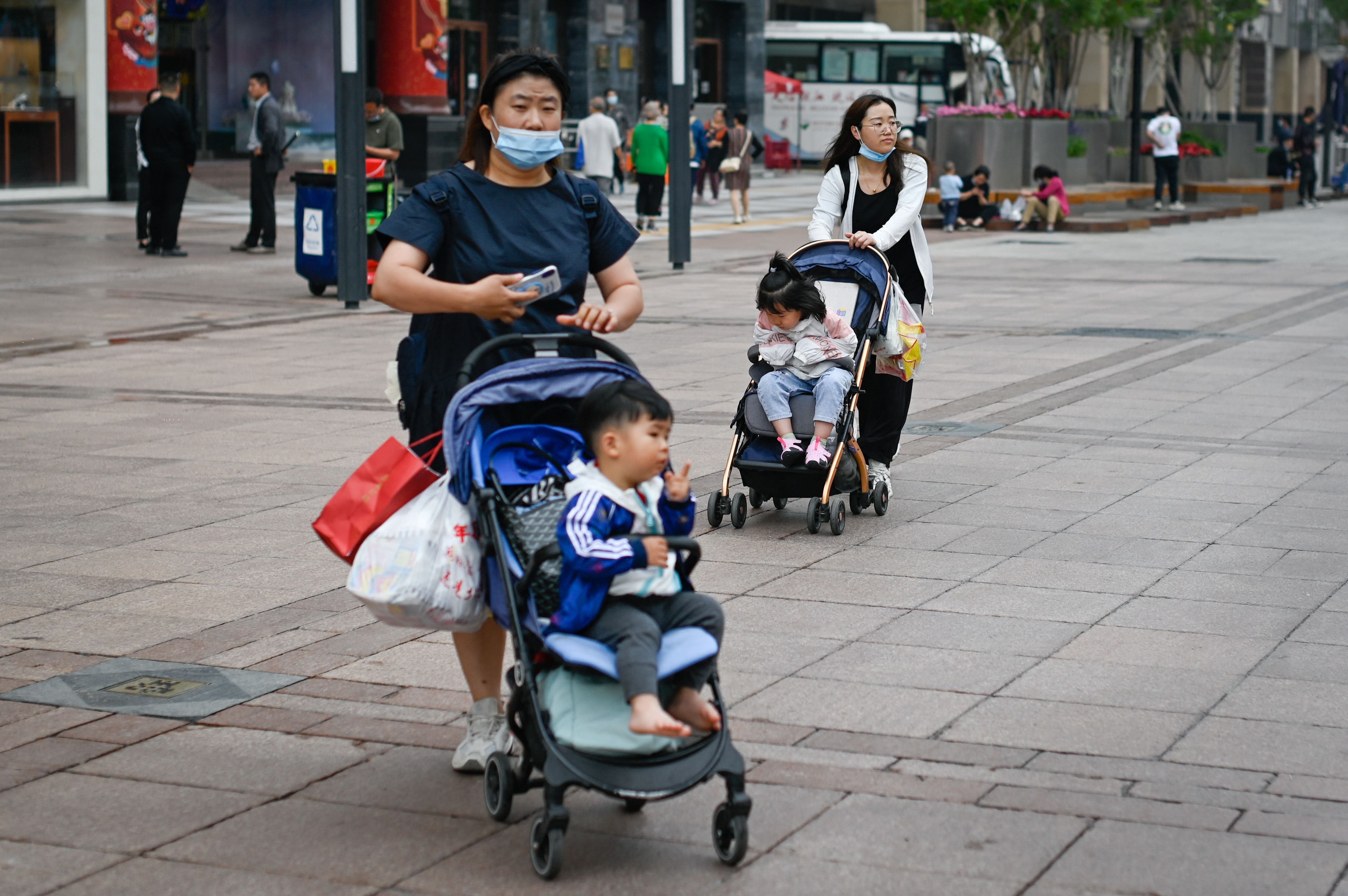 Mulheres com seus filhos em uma rua de Pequim em 31 de maio. 