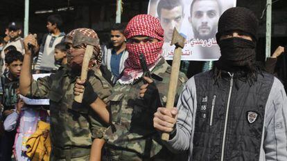 Palestinos mascarados celebram ataque a sinagoga.