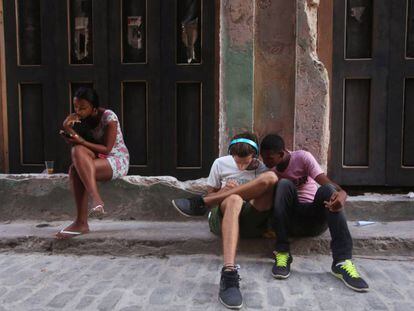Jovens usam telefones celulares em Havana.
