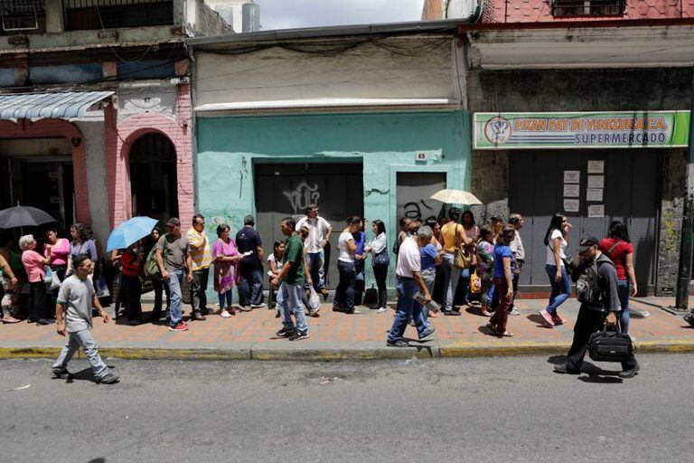Para comprar alimentos é preciso fazer longas filas nos supermercados, como neste caso, em Caracas.