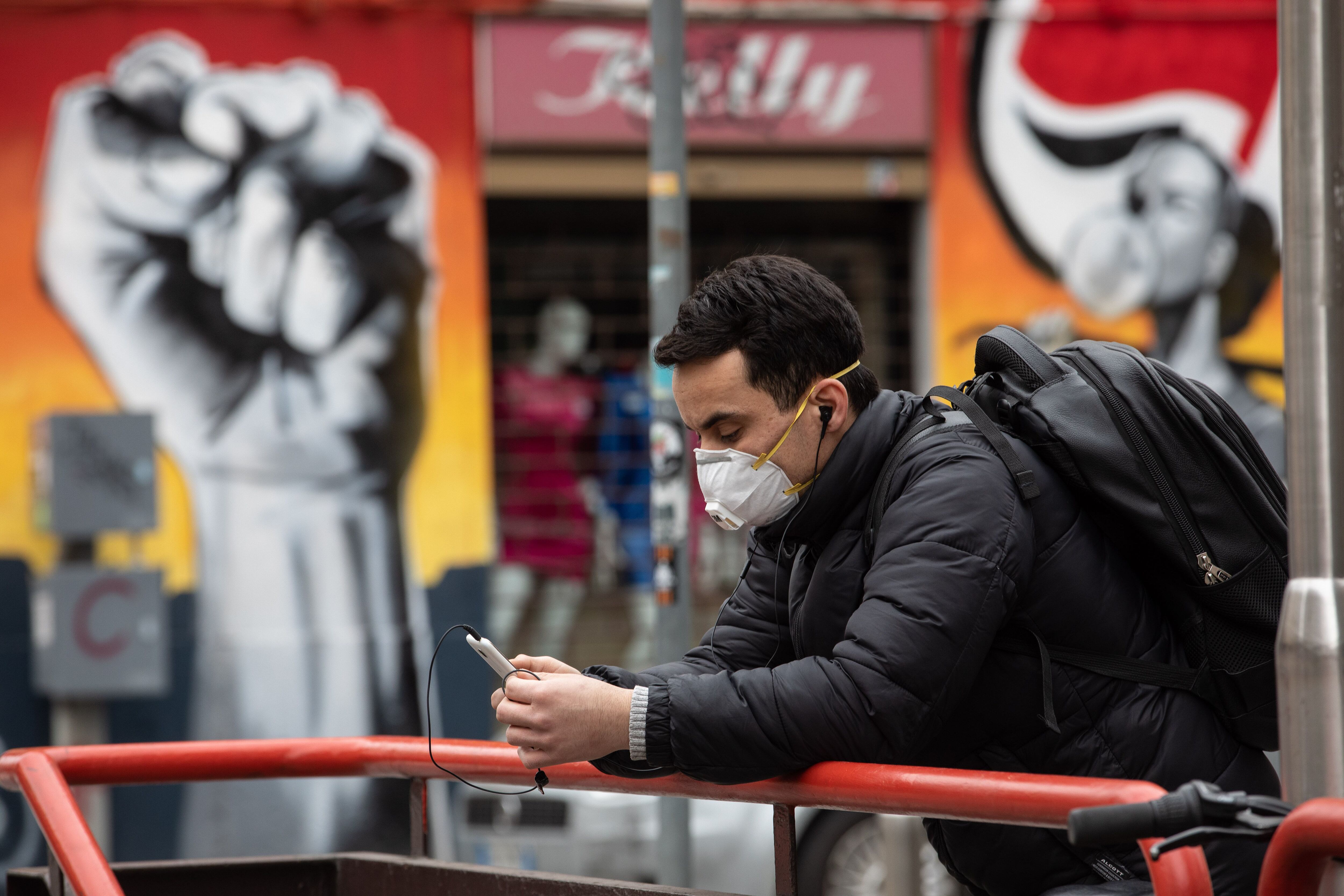 Um homem olha a tela de seu celular durante a pandemia. 