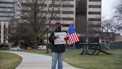 Lisa Hamm, de 61 anos, exibe um cartaz de apoio ao Colégio Eleitoral em frente ao Capitólio de Lansing, a capital do Michigan.