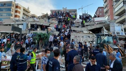 Pessoas tentam resgatar sobreviventes após um terremoto na cidade turca de Izmir, nesta sexta-feira. No vídeo, os efeitos do abalo. 