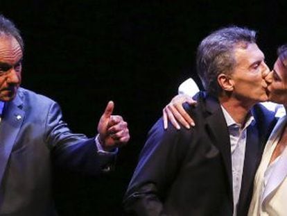 Macri recebe o beijo de sua esposa enquanto Scioli cumprimenta o público após o debate eleitoral de 18 de novembro.