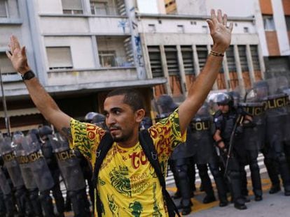 Manifestante diante de um cordão policial em São Paulo.