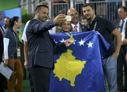 Majlinda Kelmendi, rodeada de aficionados, com a bandeira do Kosovo.