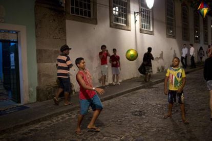 Meninos jogam bola em uma rua de Salvador.