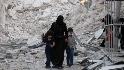 Uma família síria abandona uma área bombardeada no norte da cidade de Aleppo