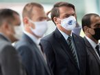 AME1058. BRASILIA (BRASIL), 20/05/2020.- El presidente de Brasil, Jair Bolsonaro (2d), sale del Palacio do Alvorada este miércoles, en Brasilia (Brasil). Brasil, el tercer país con más casos de COVID-19 en el mundo, superó este martes por primera vez la barrera de las 1.000 muertes diarias de coronavirus y registró 1.179, hasta un total de 17.971 desde el inicio de la pandemia, un récord en medio de una laguna institucional en el Ministerio de Salud. Este martes el discurso de Bolsonaro en defensa de la cloroquina, que carece todavía en el mundo científico de estudios suficientes para avalar su efectividad, sufrió otro revés por parte de la comunidad médica brasileña. EFE/ Joédson Alves
