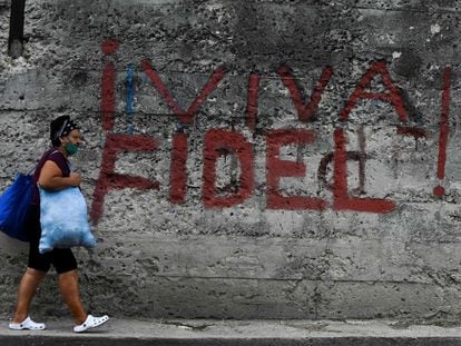 Mulher passa por pichação em que se lê Viva Fidel!, em Havana, neste 26 de julho.