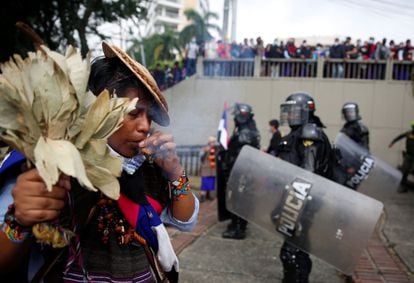 Indígena realiza um ritual junto às autoridades que tentam dispersar os manifestantes em Cali, no dia 28 de abril. Em vídeo, uma performance contra a violência. 
