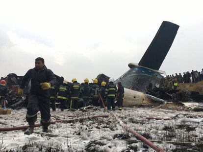 Equipe de resgate junto ao avião procedente de Bangladesh que caiu no Nepal.