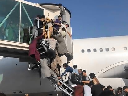 Afegãos tentam acessar um avião no aeroporto de Cabul na segunda-feira.