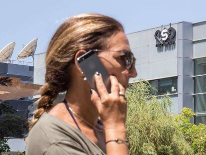 Uma mulher fala pelo celular diante do edifício do NSO Group, perto de Tel Aviv (Israel).
