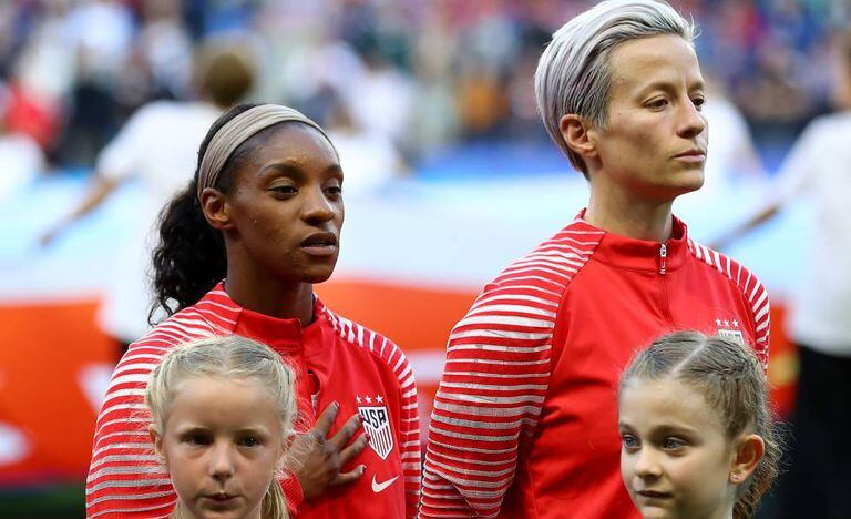 Megan Rapinoe (à direita) ouve o hino junto a Dunn.