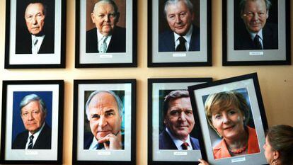 Uma mulher pendura um retrato de Merkel cinco anos atrás.