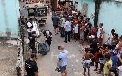 Moradores de Vitória observam a Polícia Civil retirar um corpo em uma rua no Espírito Santo, nesta sexta-feira.