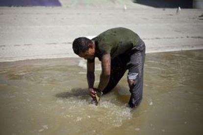 Um deportado se lava no rio.