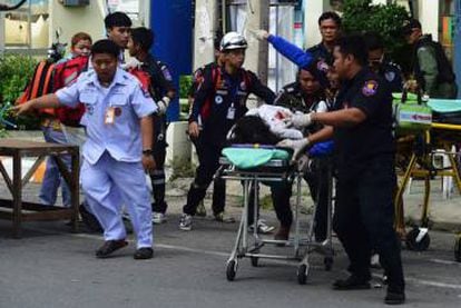 As equipes de resgate tailandeses assistem a uma vítima ferida.
