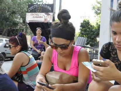 Várias pessoas se conectam à Internet na avenida 23, em Havana.