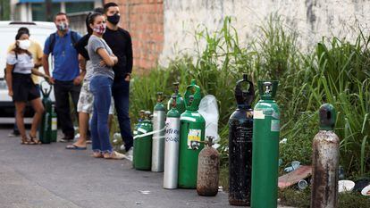 Familiares de pessoas com covid-19 aguardam em fila para reabastecer cilindros de oxigênio em Manaus.