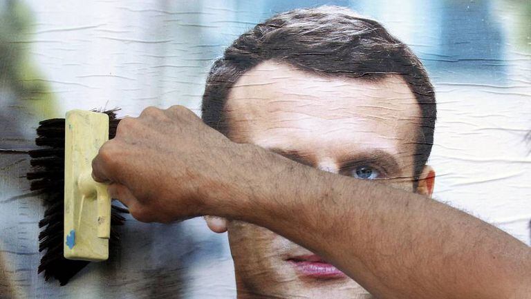 Simpatizante prega um cartaz do candidato Emmanuel Macron na quarta-feira em Bayonne.