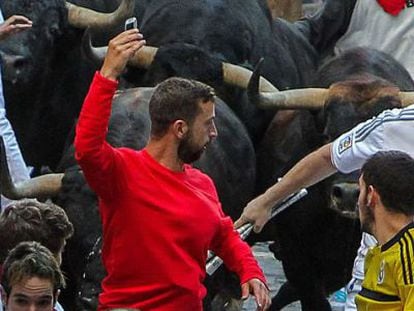 Corredor arrisca um 'selfie' diante de um touro em corrida de 2014.
