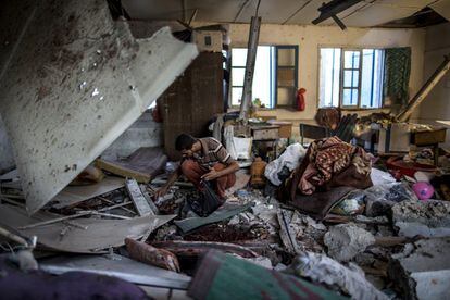 Um homem procura algo entre os escombros da escola da ONU, bombardeada no campo de refugiados de Yabalia, em 30 de julho de 2014. As Nações Unidas asseguram que milhares de pessoas estavam nas instalações quando os projéteis explodiram.