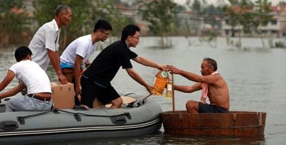 Voluntários ajudam um homem na província de Hubei.