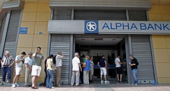 Pessoas fazem fila para sacar dinheiro em caixas eletrônicos em Atenas.