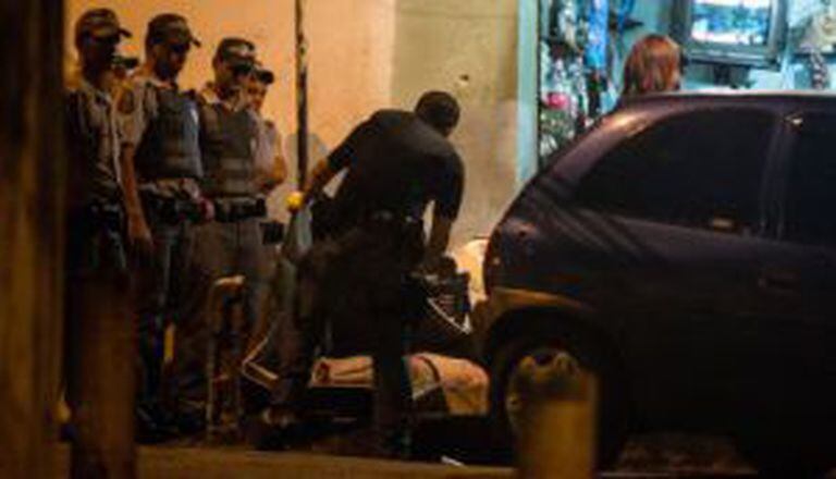Policiais recolhem corpo de vítima de chacina no Campo Limpo.