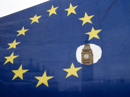 O Big Ben observa-se através de uma bandeira europeia furada.