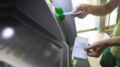 Usuário retira dinheiro de um caixa eletrônico em Madri.