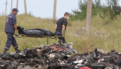 Dois ucranianos levam os restos das vítimas do voo MH17.