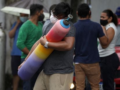 Um homem carrega um cilindro de oxigênio em Manaus.