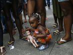 Kimberly, 1, holding a doll with fake blood, is seen during a protest against the killing of her cousins Emily Victoria Silva dos Santos, 4, and Rebeca Beatriz Rodrigues dos Santos, 7, in Duque de Caxias, Rio de Janeiro state, Brazil, Sunday, Dec. 6, 2020. The girls, cousins, were killed by stray bullets while playing outside their homes. (AP Photo/Bruna Prado)