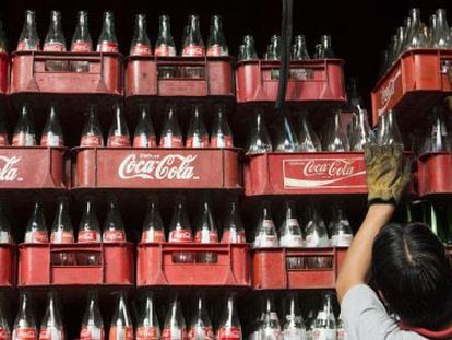 Um trabalhador empilha caixas de garrafas de Coca-Cola, no México.