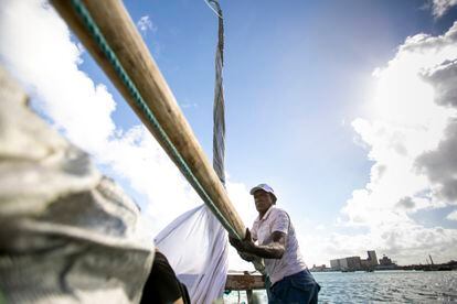 O pescador Luciano Preto maneja o mastro da jangada para levantar a vela.