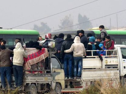 Um grupo de sírios abandona, na sexta-feira, os bairros rebeldes de Aleppo.