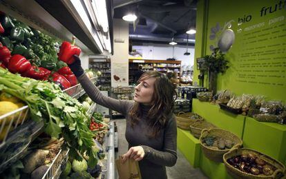 Uma mulher compra vegetais ecológicos.