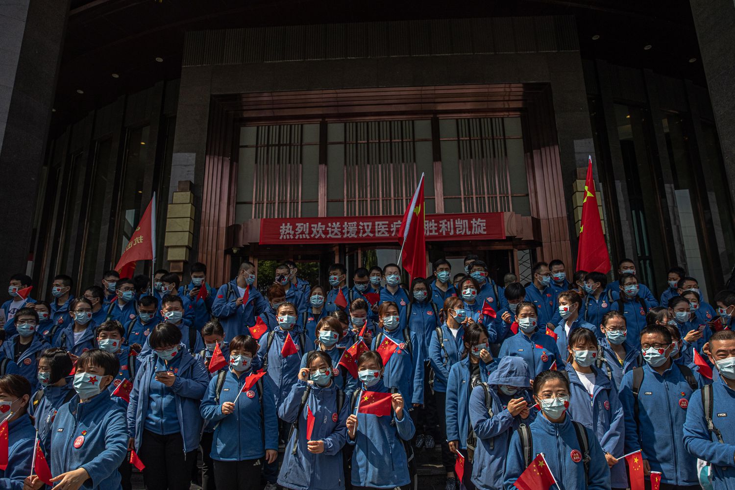 Trabalhadores de saúde chineses da província de Shandong participam de uma cerimônia antes de deixar Wuhan.