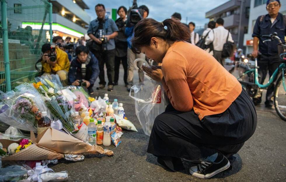 Uma mulher reza diante do local onde um homem atacou um grupo de estudantes com uma faca em Kawasaki, no Japão.