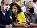 Supporters of Brazil's President Jair Bolsonaro wear face masks amid the new coronavirus pandemic decorated with his image during the president's departure from his official residence, Alvorada palace, Brasilia, Brazil, Monday, May 25, 2020. (AP Photo/Eraldo Peres)