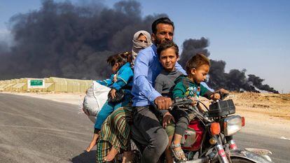 Uma família de deslocados abandona a cidade curda de Ras al Ain na quarta-feira.