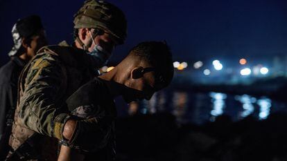 Soldado conduz imigrante que saía da água na praia de El Tarajal, em Ceuta.