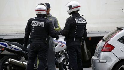 Policial francesa revista um homem no centro de Paris.