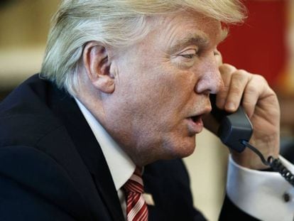 O presidente Donald Trump fala ao telefone em seu gabinete em janeiro de 2017.