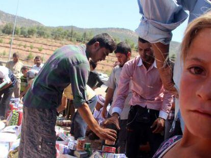 Refugiados yazidis recebem ajuda nas proximidades de Dohuk.