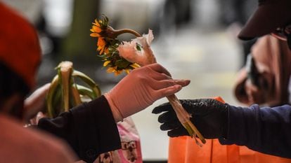 Mulher recebe flores e mantimentos durante ação social no Harlem, em Nova York, para o Dia das Mães.