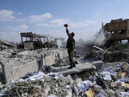 Soldado sírio filma os destroços após o bombardeio aliado.